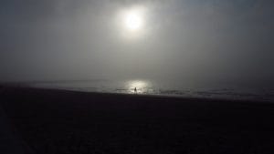 Pleine lune cachée par la brume et qui se reflète dans le lac